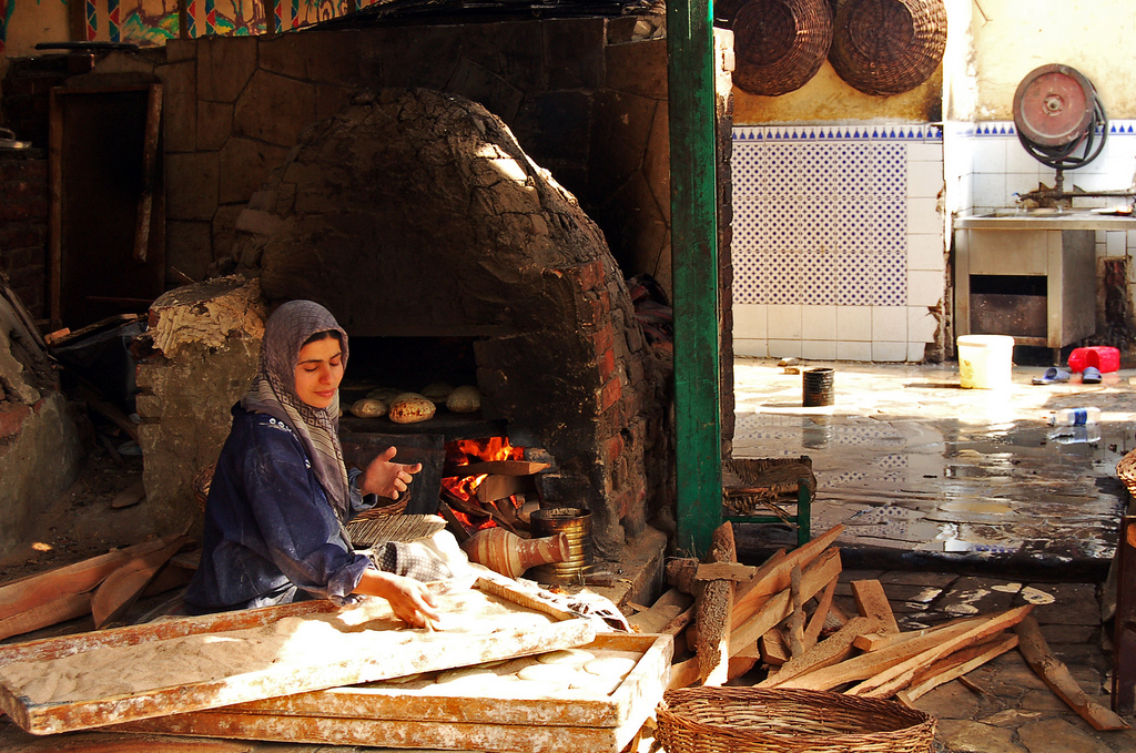 Young woman making bread, a symbol of Egyptian Hospitality.