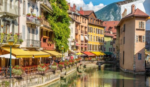View of Annecy, the largest city in Haute-Savoie, with canals, historic buildings, and the French Alps in the background