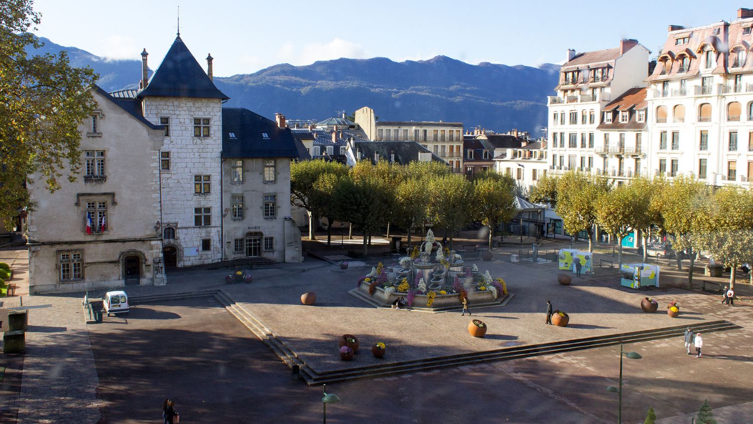 Aix-les-Bains historic city centre with Alpine mountains in the background, highlighting architecture and town square activity.