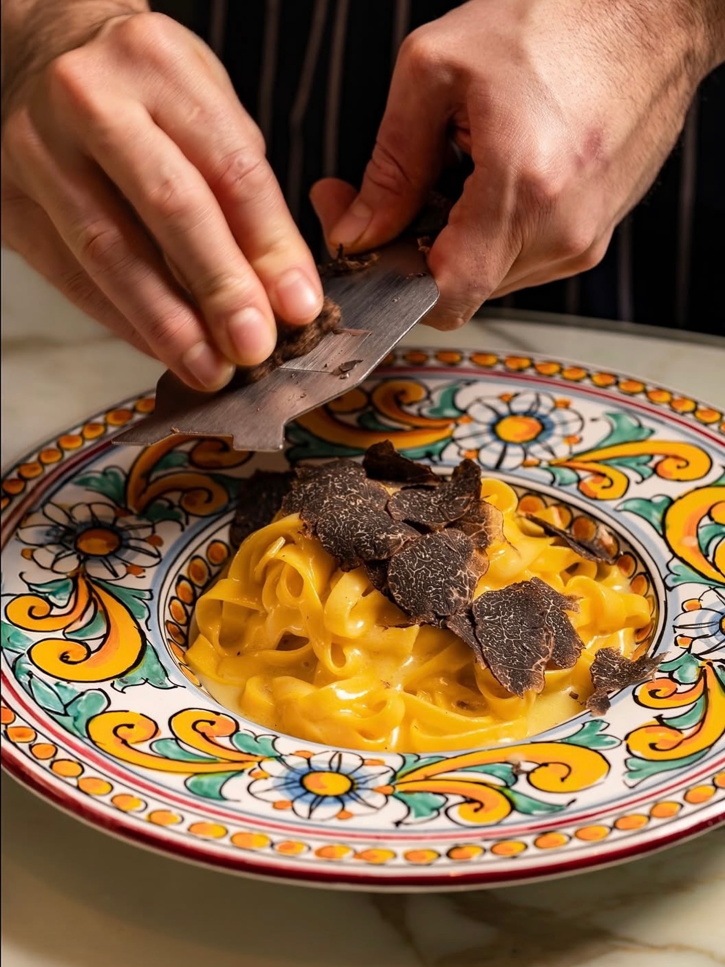 Fresh black truffles being shaved over creamy pasta, illustrating Marco Tallarico’s advice that truffles shine on dishes like popcorn, eggs, pasta, steak, and fries.