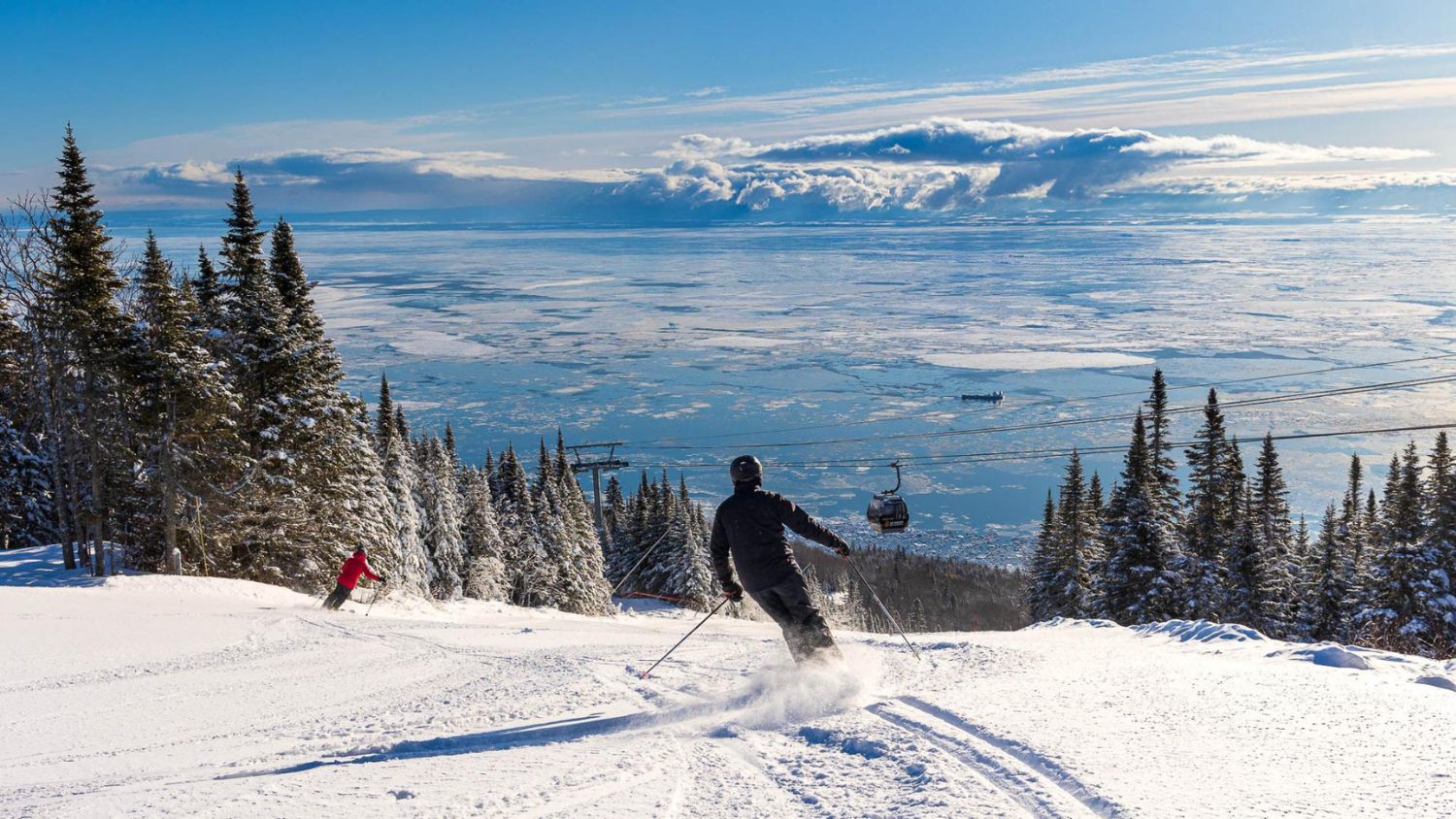 Downhill skiers embrace the breathtaking views at Le Massif de Charlevoix.