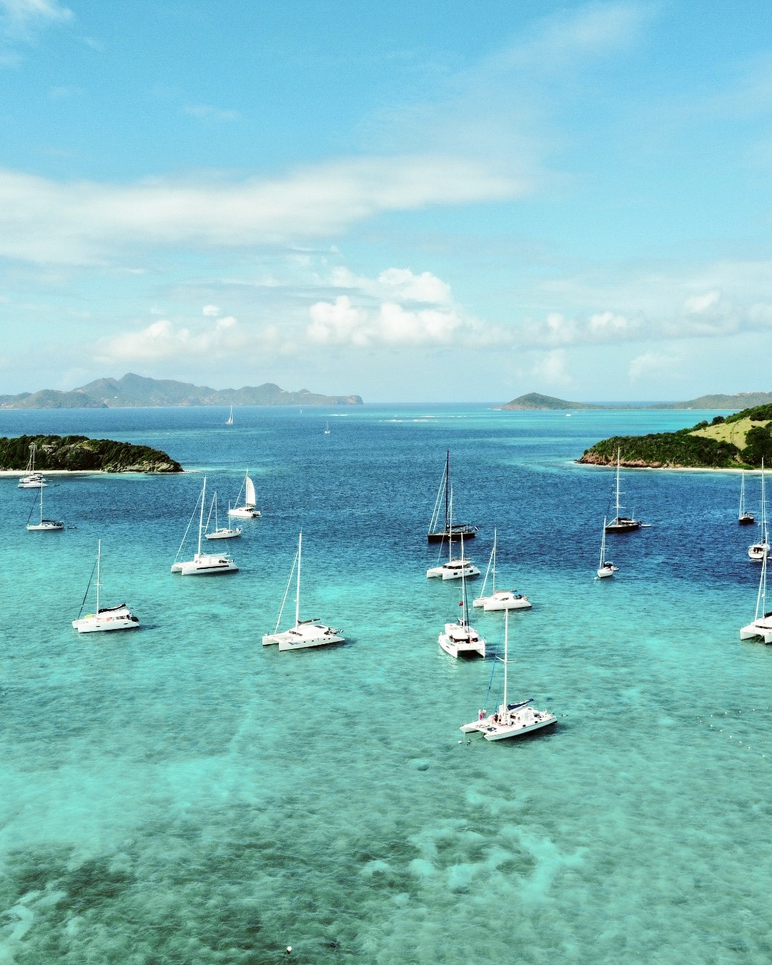 Sailboats anchored in the turquoise shallows off Union Island, St. Vincent and the Grenadines — where island life moves at its own pace