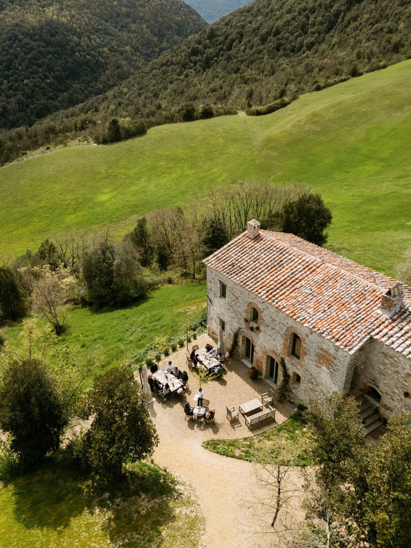 A table set with wine and rustic Umbrian dishes at Il Caldaro, the signature restaurant at Tenuta di Murlo in Umbria, Italy.