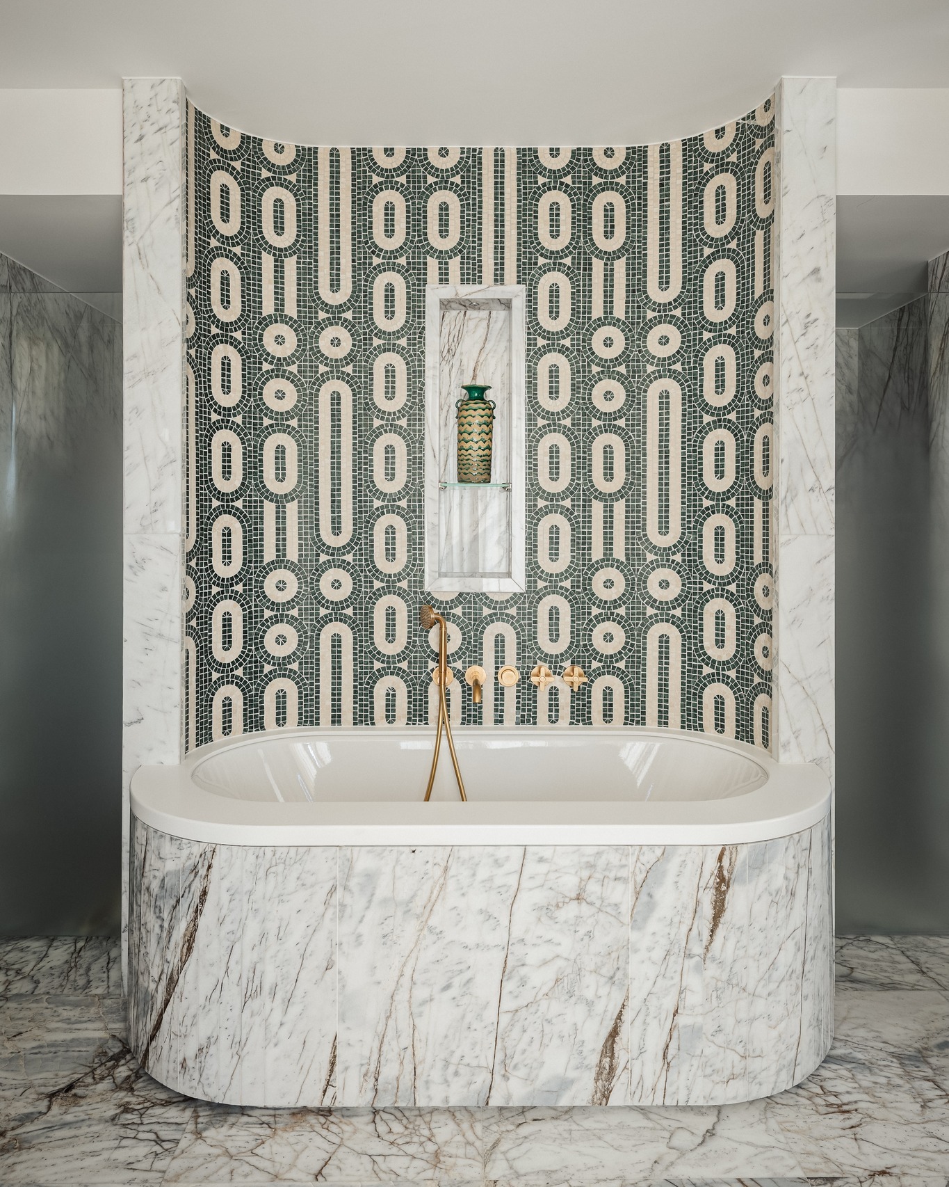 Luxurious bathroom in the Eiffel Suite at Hôtel de Sers, featuring a central white marble soaking tub, handcrafted Italian mosaic wall, and gilded brass fixtures.