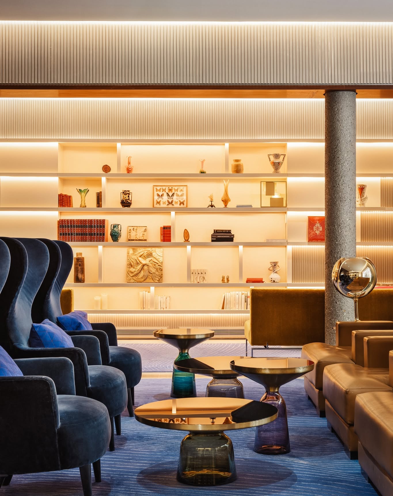 Contemporary library lounge at Hotel de Sers featuring sleek shelving, bold colours, and modern décor.