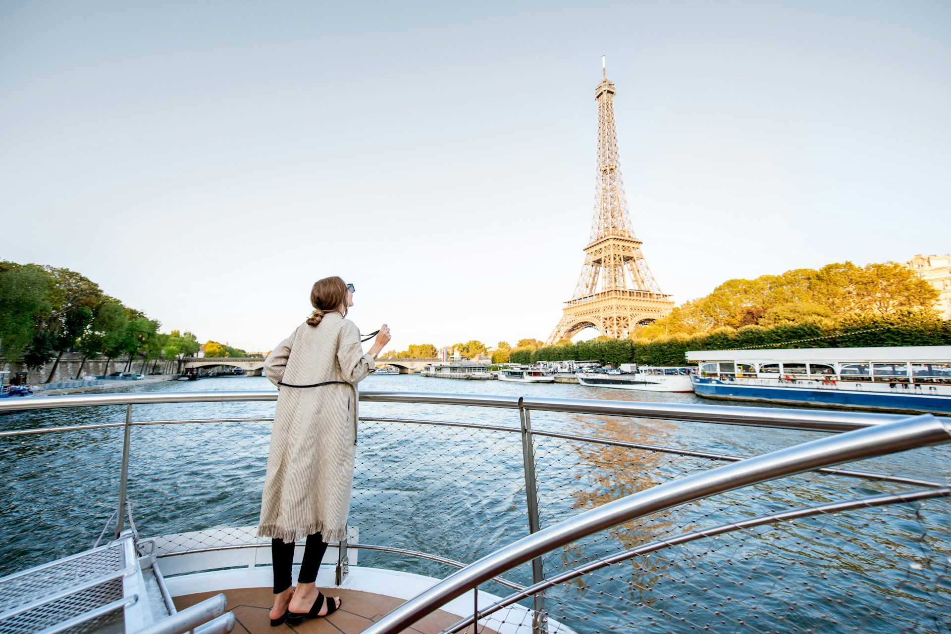 Solo traveller cruising along the Seine River with the Eiffel Tower in view, capturing the magic of Paris from the water.