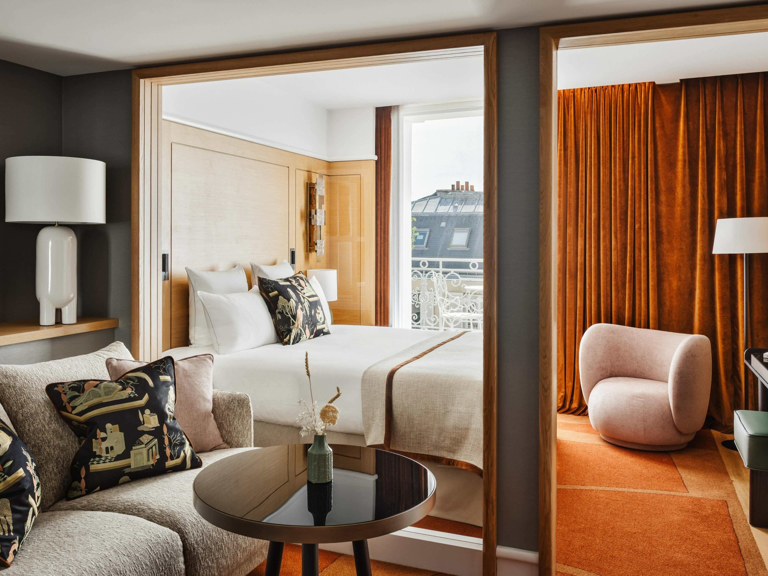 Executive suite at Hotel de Sers with plush bed, velvet curtains, and Parisian balcony views.
