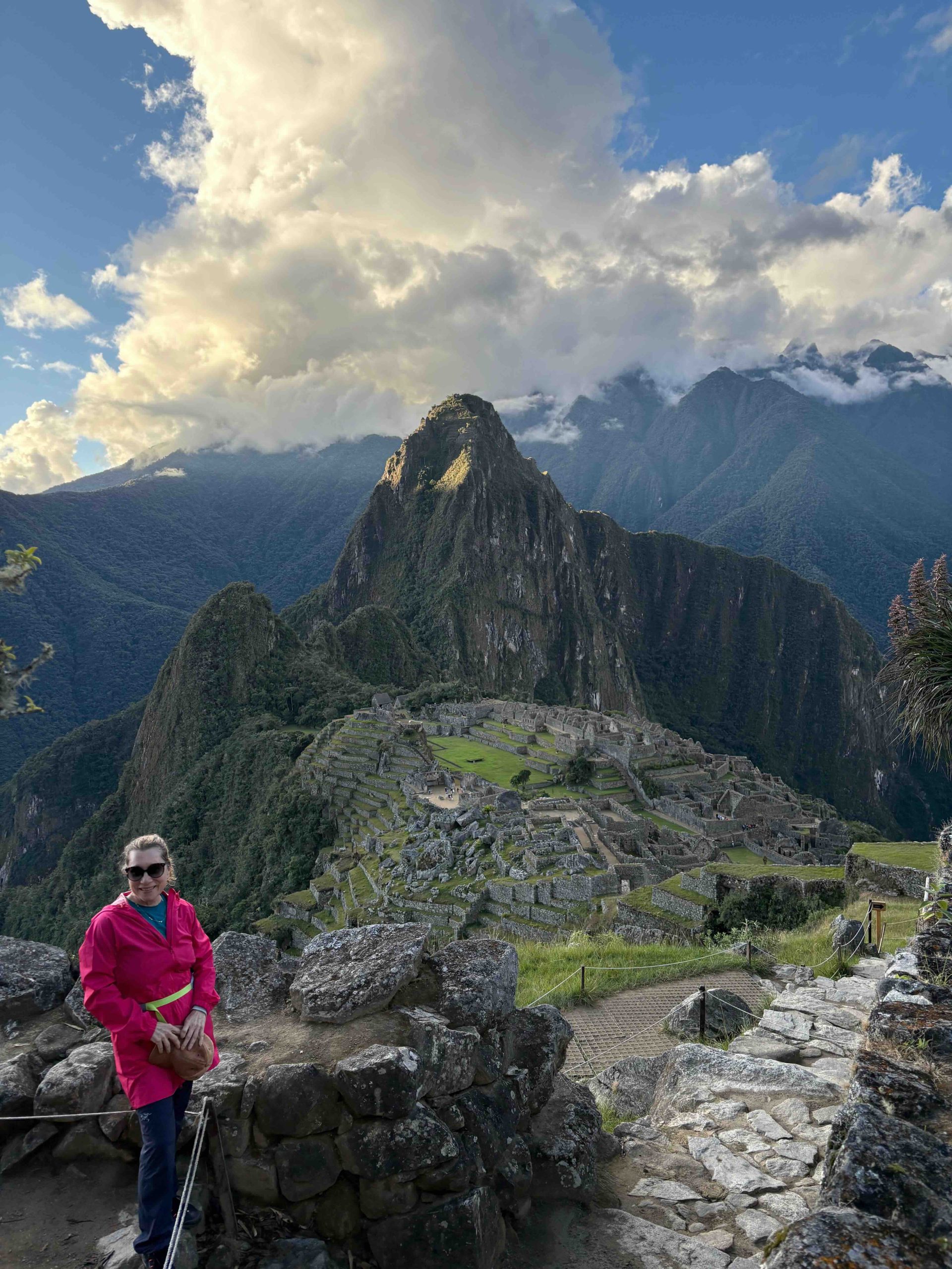 A journey of 23,000 steps culminates here. Vivian Vassos arrives at the Sun Gate as the sun sets over the sprawling wonder of Machu Picchu below.
