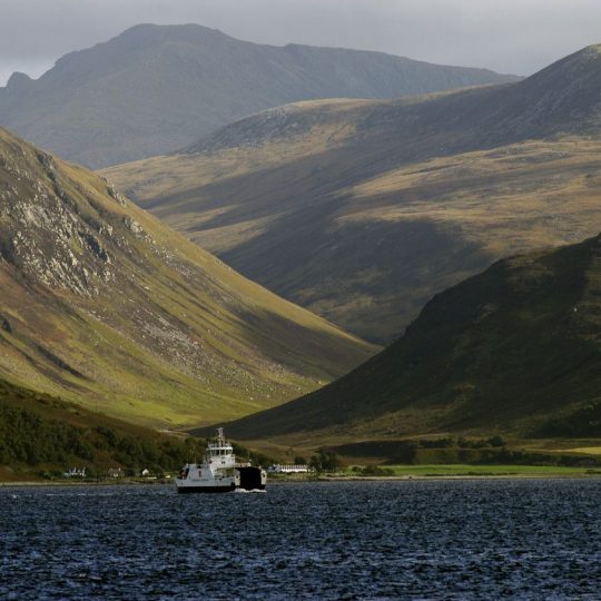 The ferry from the Isle of Arran to Skipness on Kintyre Argyll. The hills of Arran and the tiny village of Catacol in the background