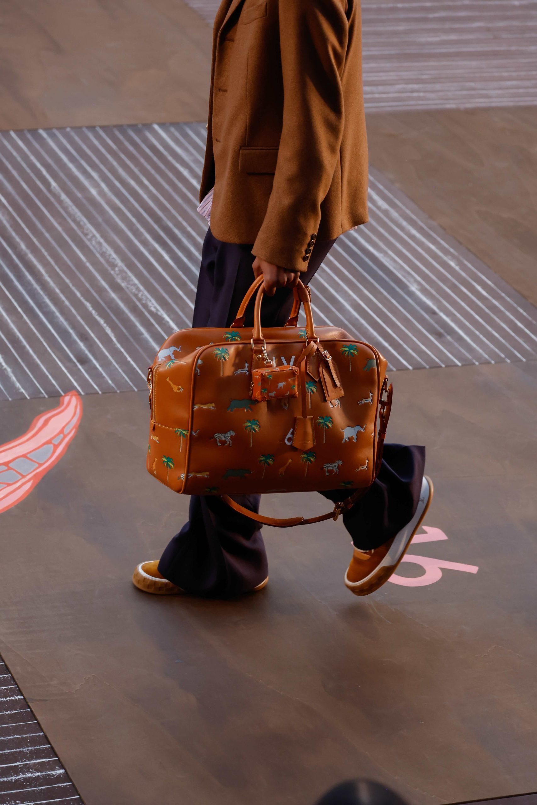 sporting The Darjeeling Limited patterned luggage and the LV Tilted sneaker at the Louis Vuitton men’s S/S 26show